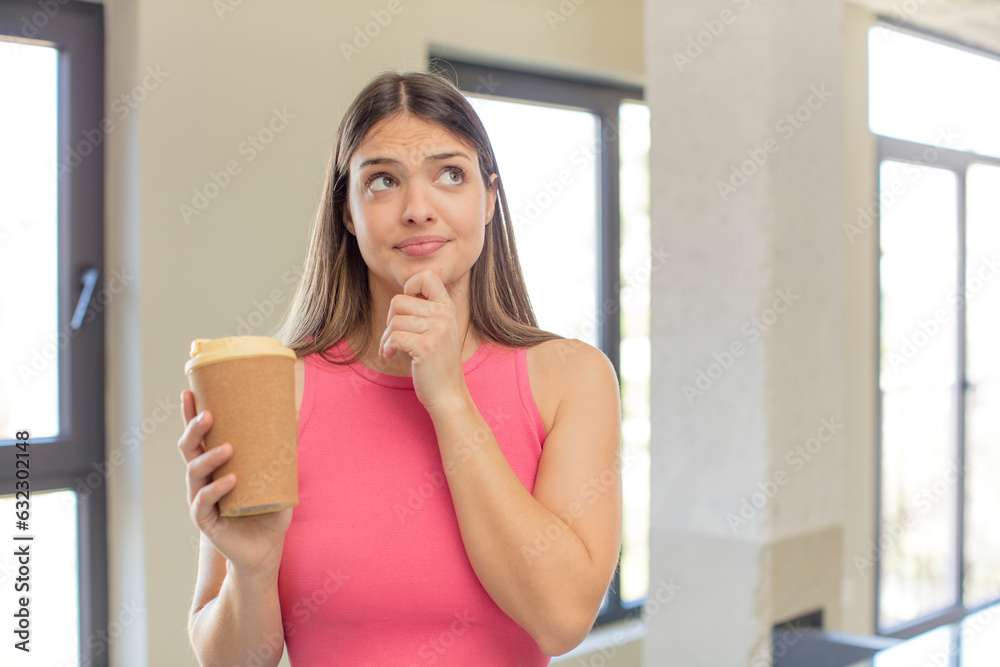 young pretty woman smiling with a happy, confident expression with hand on chin. take away coffee concept