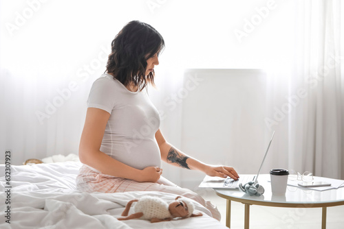 Young pregnant woman workin...