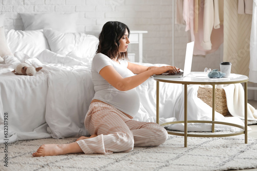 Young pregnant woman workin...