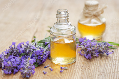 Lavender essential oil and extract in glass bottle with fresh flower and leaf on rustic wooden background  closeup  spa  skin care  aroma therapy  beauty treatment concept
