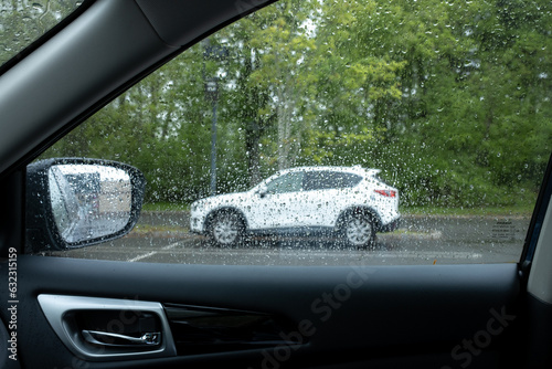 cars parked in parking lot on rainy day © Michele