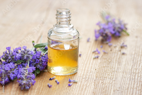 Lavender essential oil and extract in glass bottle with fresh flower and leaf on rustic wooden background  closeup  spa  skin care  aroma therapy  beauty treatment concept