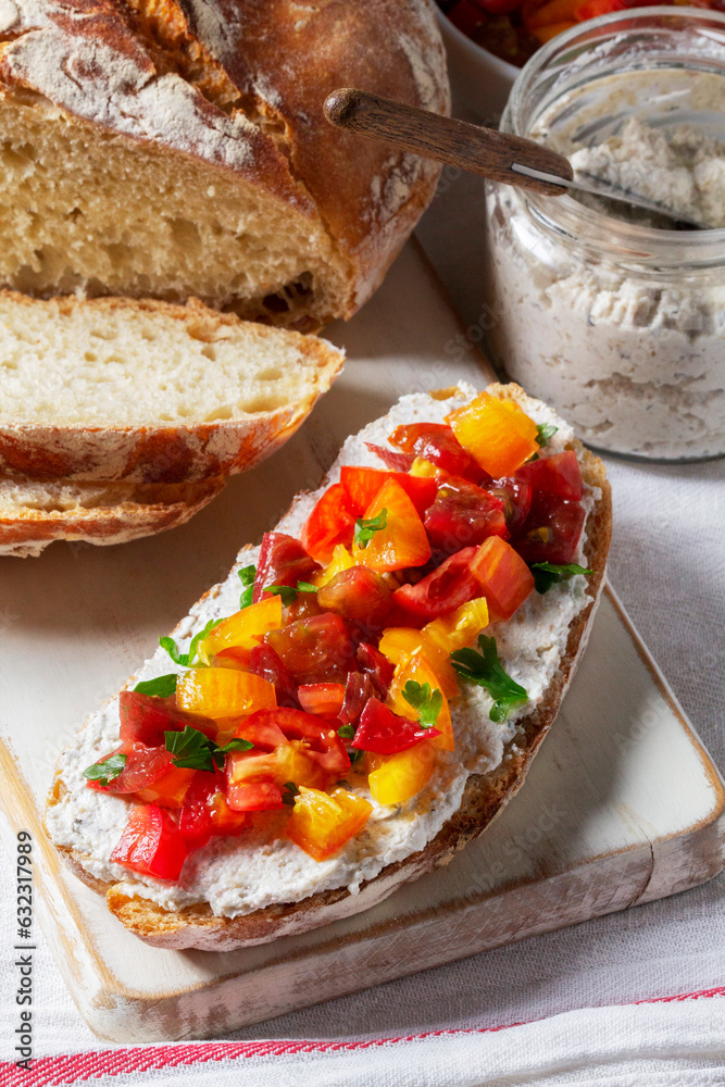 Bruschetta from homemade bread with cottage cheese and sprat pate and tomatoes on a wooden background. Rustic style.