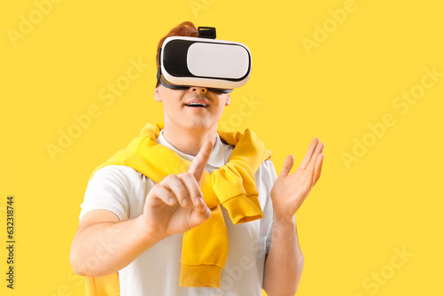 Young man in VR glasses usi...