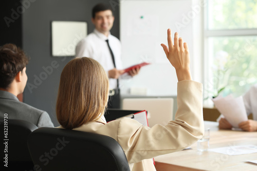 Female business consultant raising hand during presentation in office, back view © Pixel-Shot