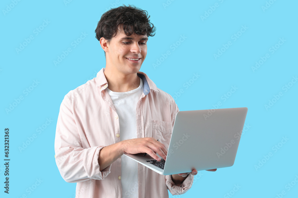 Male programmer working with laptop on blue background Male programmer working with laptop on blue background