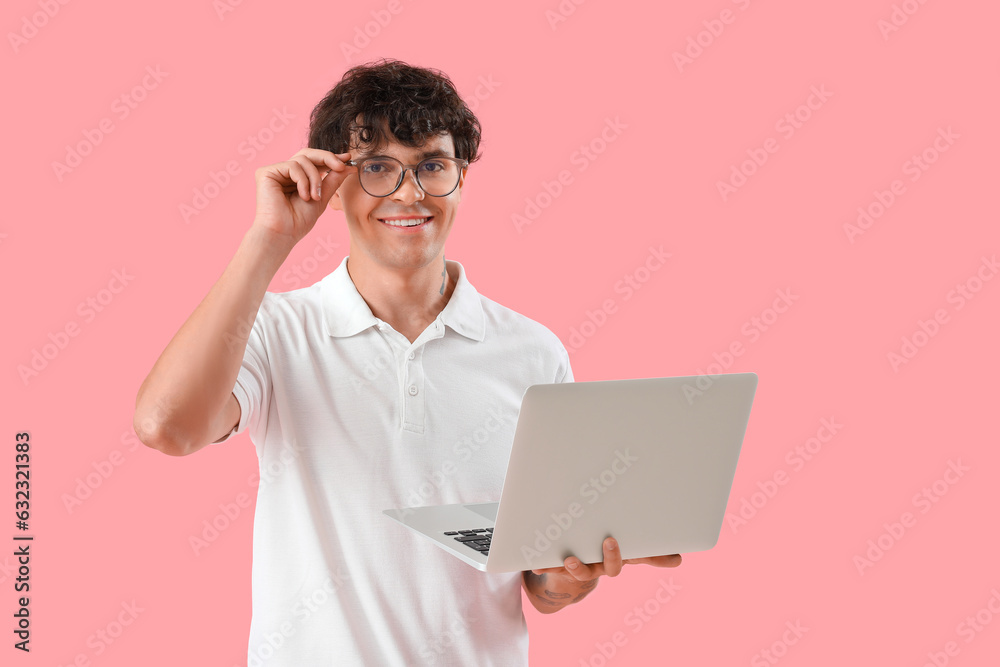 Male programmer with laptop on pink background Male programmer with laptop on pink background