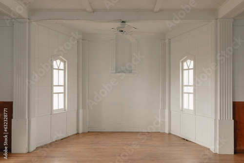 espace creux dans une pièce avec de grands murs blancs et des petites fenêtres au milieu des deux murs opposés