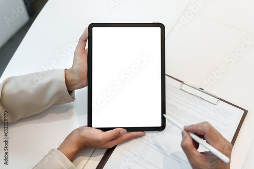 Business people holding empty screen tablet at work desk