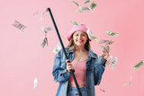 Happy young woman with fishing rod and money on pink background