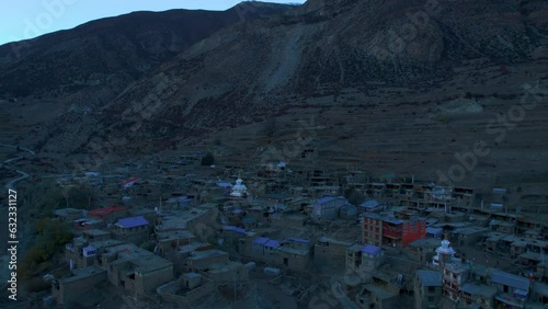 Aerial fly over Manang village house rooftops in Himalayas mountain range valley. Nepalese guest houses architecture and community concept. Trekking destination in Nepal. photo