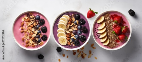 Pink and black currant berries are featured in a banana smoothie bowl on a light gray concrete background.