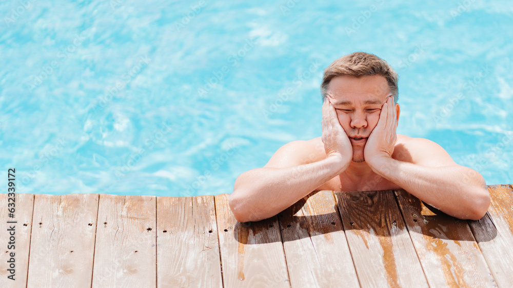 Portrait of a sad and dreamy middle-aged man in the pool at the side.