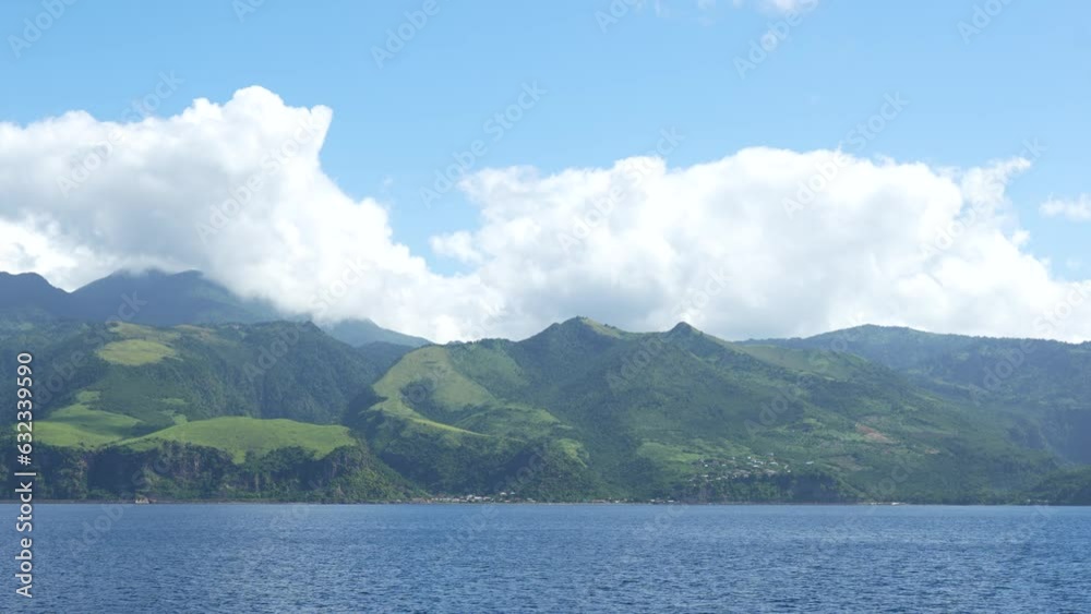 View from a ferry on the Caribbean Sea and natural hilly land covered with trees of Dominica 