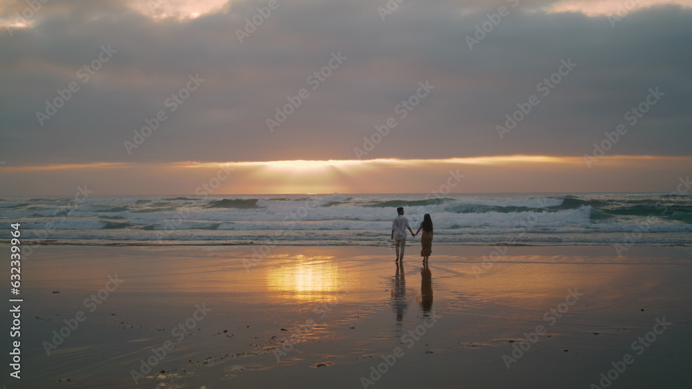 Sweethearts silhouettes walking sunbeams sea. People enjoying romantic date