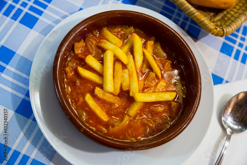 Popular Spanish Callos en salsa con patatas, tripe braised in tomato sauce garnished with potatoes photo