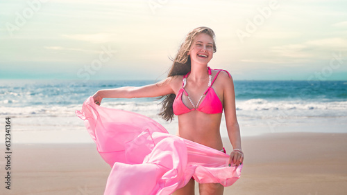 young woman standing on the beach smiling in a swimsuit