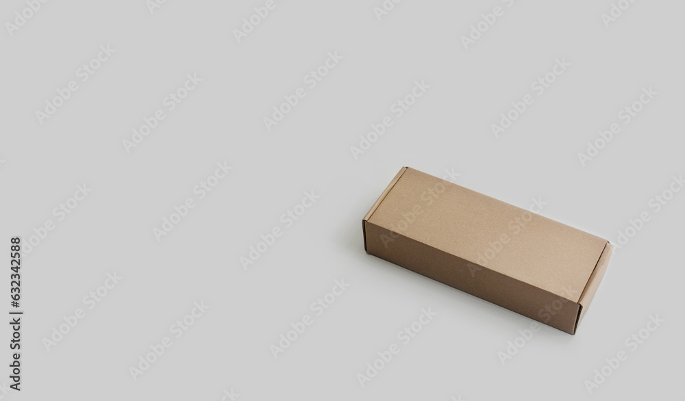 A rectangular cardboard parcel box on a light background. No people, no text. Copy space. Sustainability. Minimalism A rectangular cardboard parcel box on a light background. No people, no text. Copy space. Sustainability. Minimalism