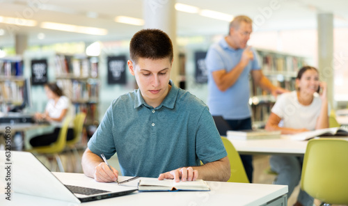 Smart male student preparing for the exam in the school library