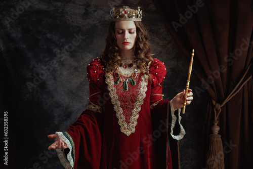medieval queen in red dress with wand and crown
