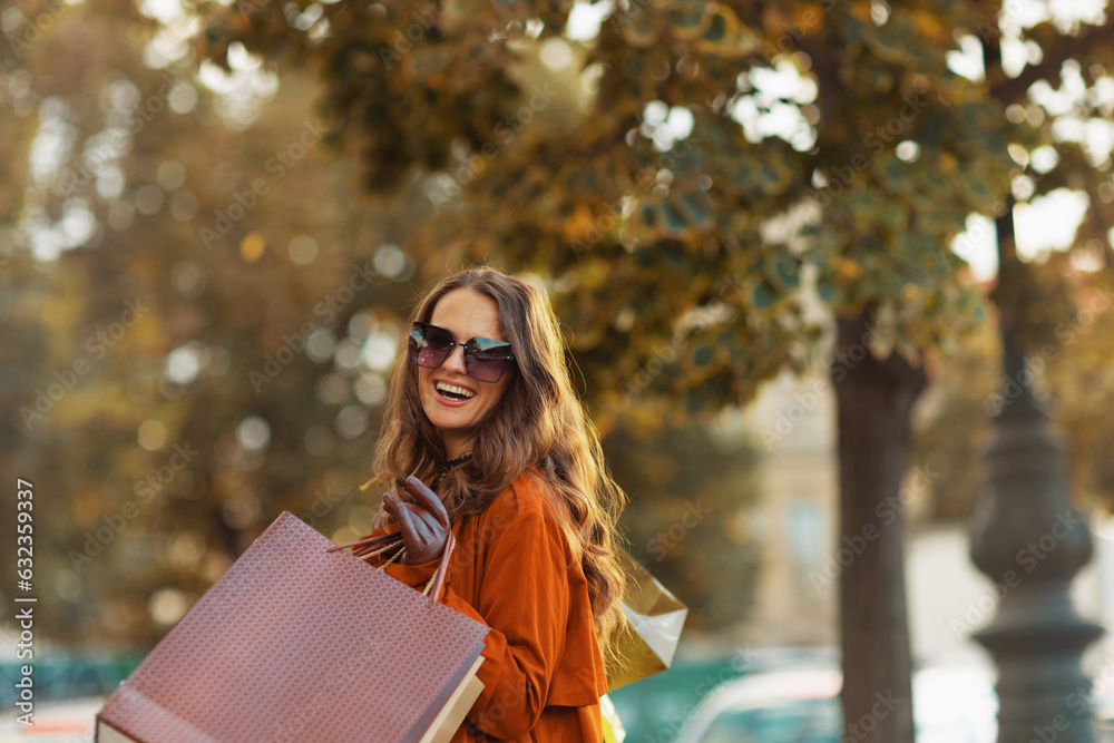 happy elegant female in brown trench coat with shopping bags happy elegant female in brown trench coat with shopping bags