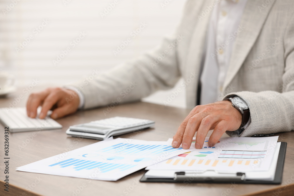 Professional accountant working at wooden desk in office, closeup Professional accountant working at wooden desk in office, closeup
