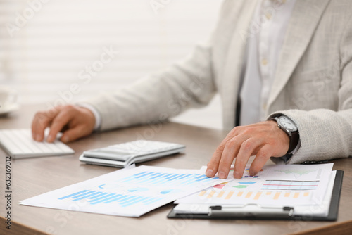 Professional accountant working at wooden desk in office, closeup