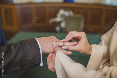 Pan młody zakłada Pani młodej pierścionek na palec. Ślub w urzędzie. Obrączka na palcu. The groom puts a ring on the bride's finger. Wedding at the office. A ring on a finger.