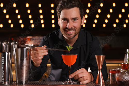 Bartender preparing fresh alcoholic cocktail in bar