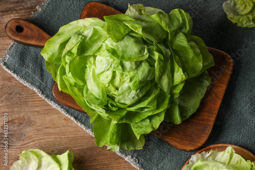 Fresh green butter lettuce on wooden table, flat lay