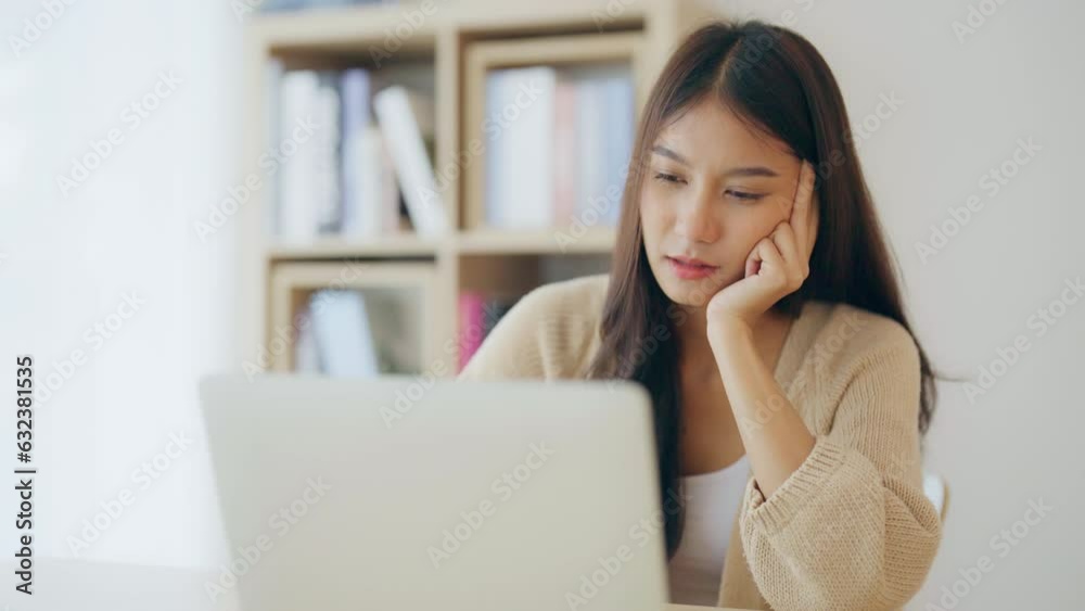 Young asian woman working at home. Happy female using computer laptop on desk at house Young asian woman working at home. Happy female using computer laptop on desk at house