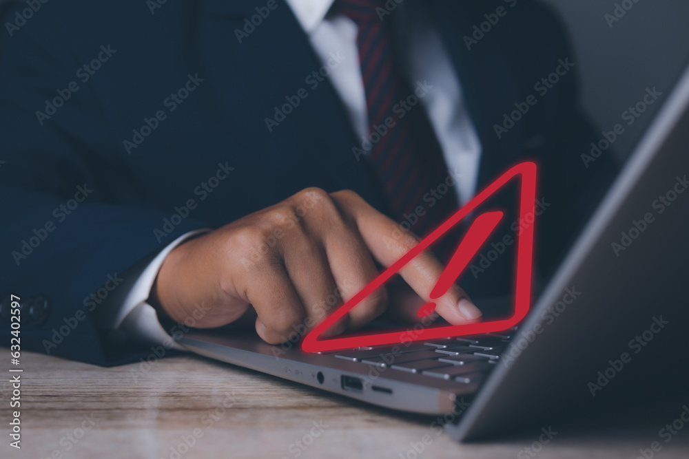 Businessman using laptop computer with triangle caution warning sign for notification error. Notification error and maintenance, Programmer with hacker attacks, cyber crime and security. Businessman using laptop computer with triangle caution warning sign for notification error. Notification error and maintenance, Programmer with hacker attacks, cyber crime and security.