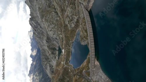 Aerial View Of Dam Separating Lake Naret And Lake Scuro In Switzerland. Vertical Video, Parallax Shot photo