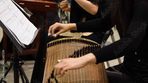 a female player playing traditional  instruments Chinese zither or guzheng.