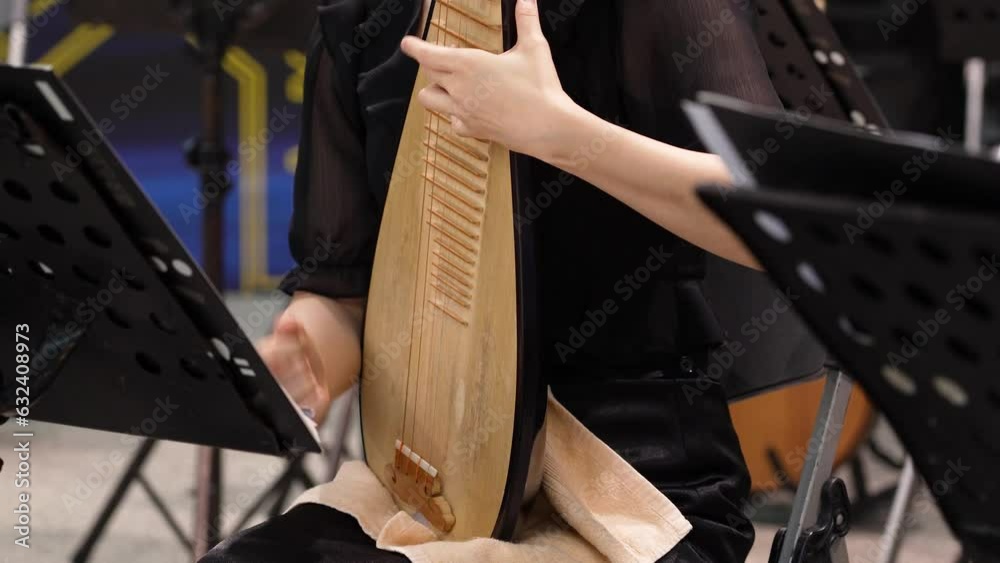 a female player playing traditional instruments Chinese lute or Pipa.