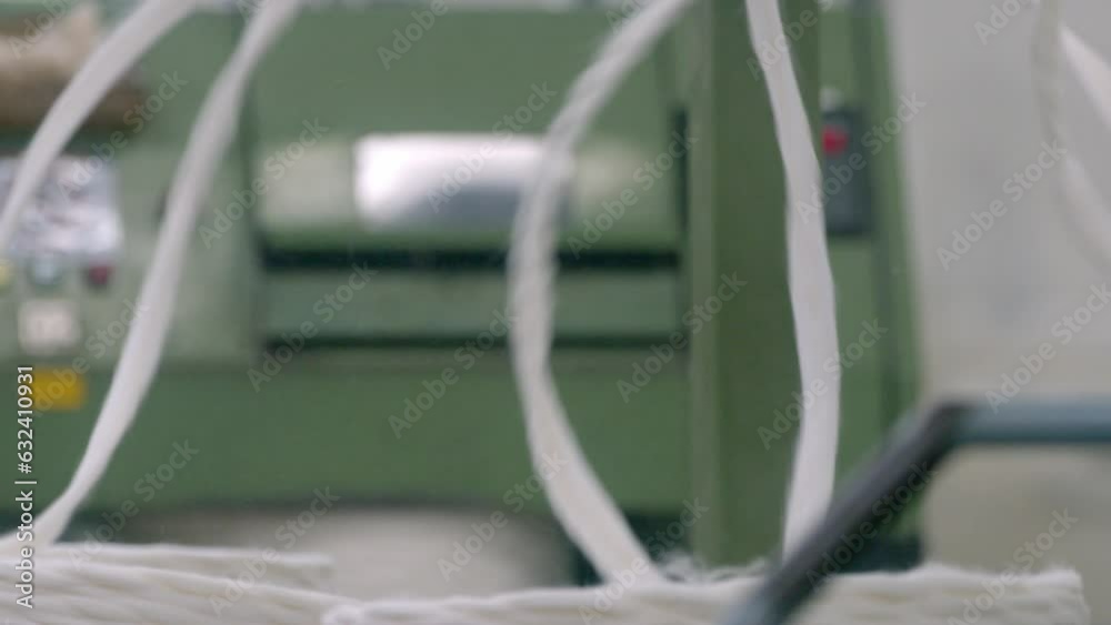 Cotton being spun on a modern spinning machine in a textile factory Cotton being spun on a modern spinning machine in a textile factory