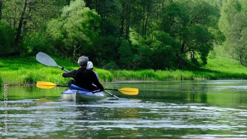 Family kayak trip for seigneur and senora. An elderly married couple rowing a boat on the river, a water hike, a summer adventure. Age-related sports, mental youth and health, tourism, active old age photo