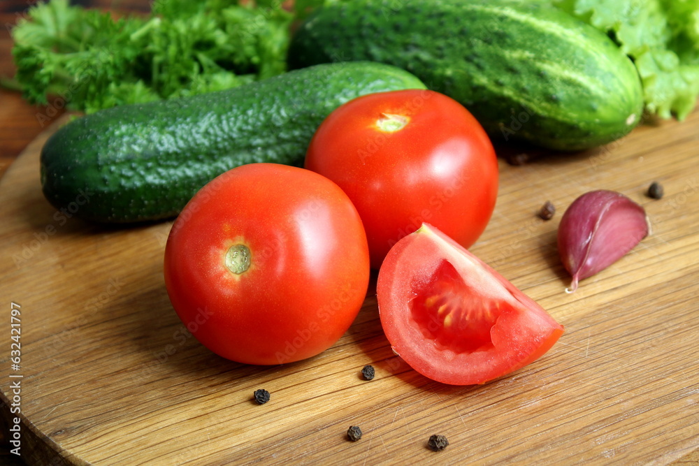 Tomatoes lie on a wooden cutting board. Tomatoes lie on a wooden cutting board.