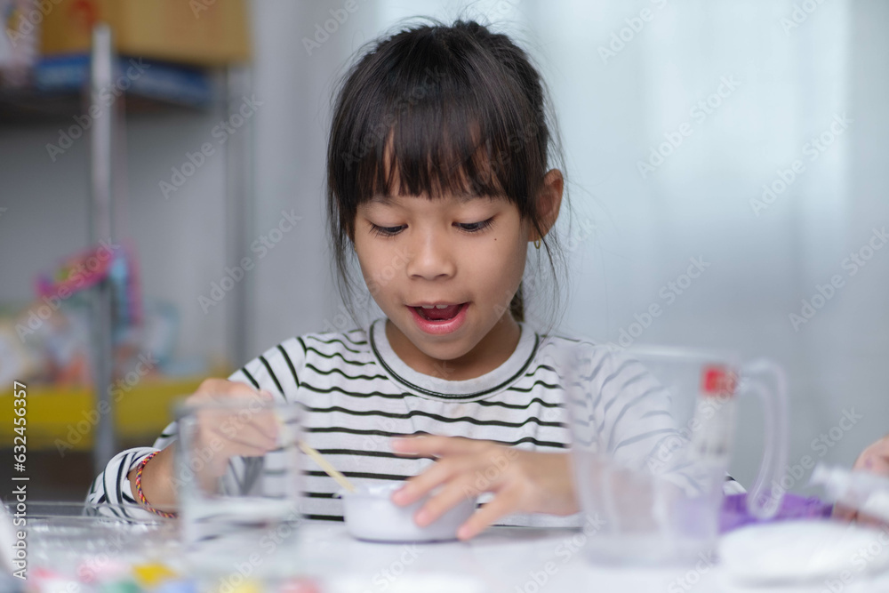 Cute little girl making DIY plaster and painting at home. Children