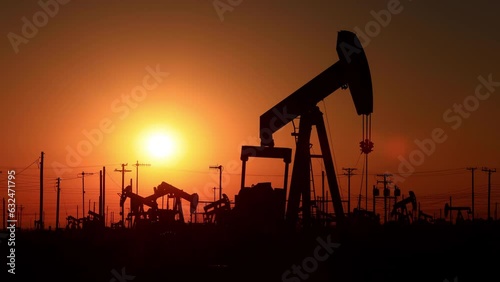 The sun rises behind oil pumps in California