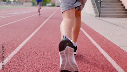 2 boys runs on their school's track.