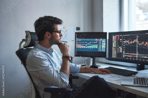 Busy working day. Side view of successful trader or businessman in formal wear and eyeglasses working with charts and market reports on computer screens in his modern office