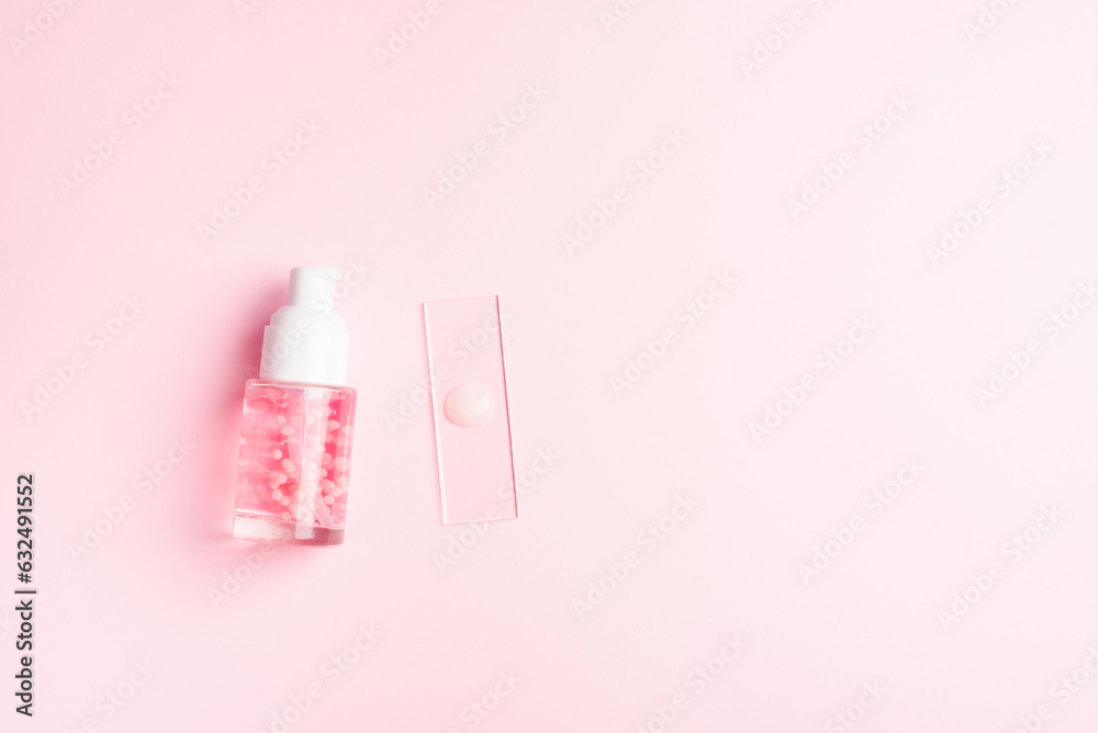 Liquid cosmetic product with pink molecules. Cosmetic laboratory concept. Product sample on laboratory glass