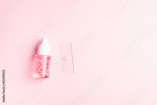 Liquid cosmetic product with pink molecules. Cosmetic laboratory concept. Product sample on laboratory glass