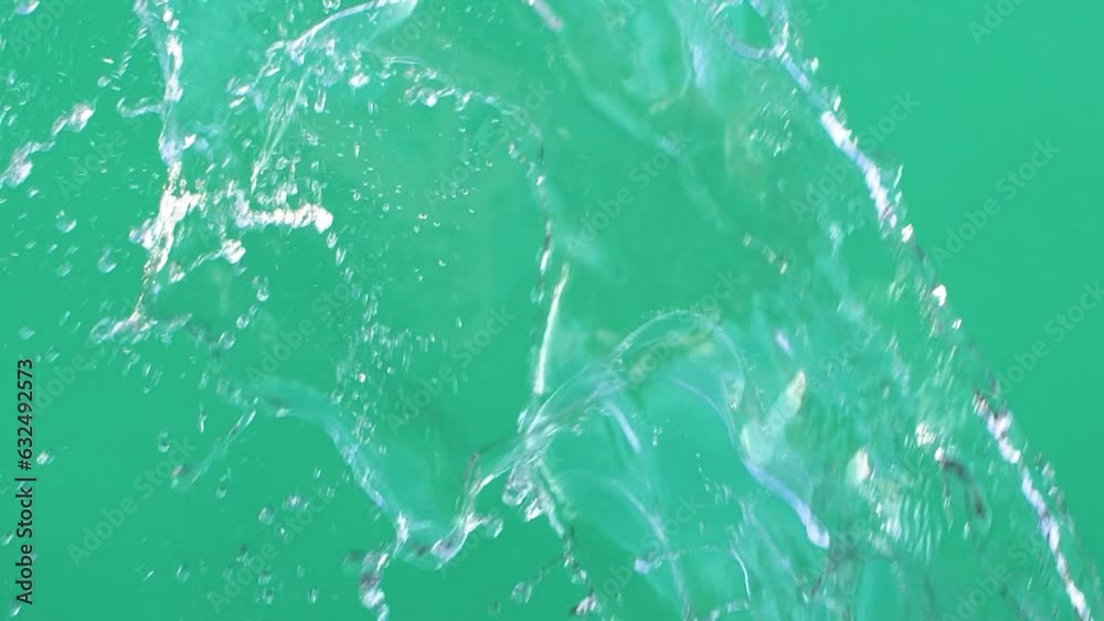Slow motion of water splashing with drops on green screen chroma key background