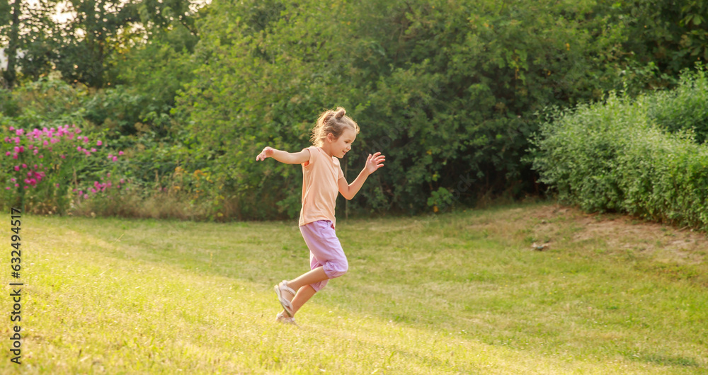 Happy girl jumping and running on the green lawn, schoolchildren summer vacation, fun and outdoor games.
Happy girl jumping and running on the green lawn, schoolchildren summer vacation, fun and outdoor games.