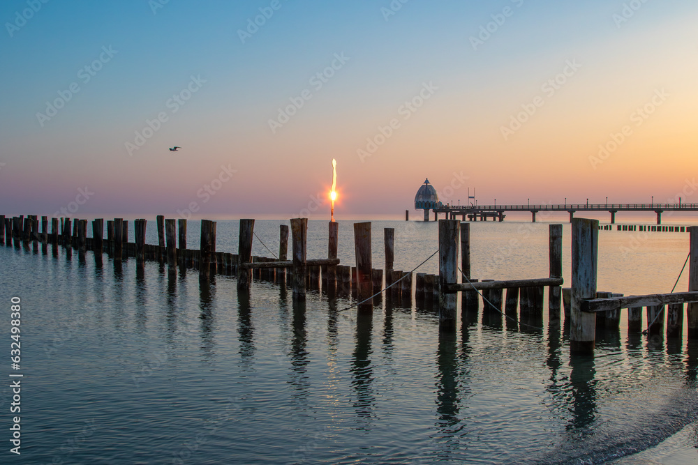 Obraz premium Zum Sonnenaufgang mit Sea Daughter, Spiegelfrau am Strand von Zingst an der Ostsee.