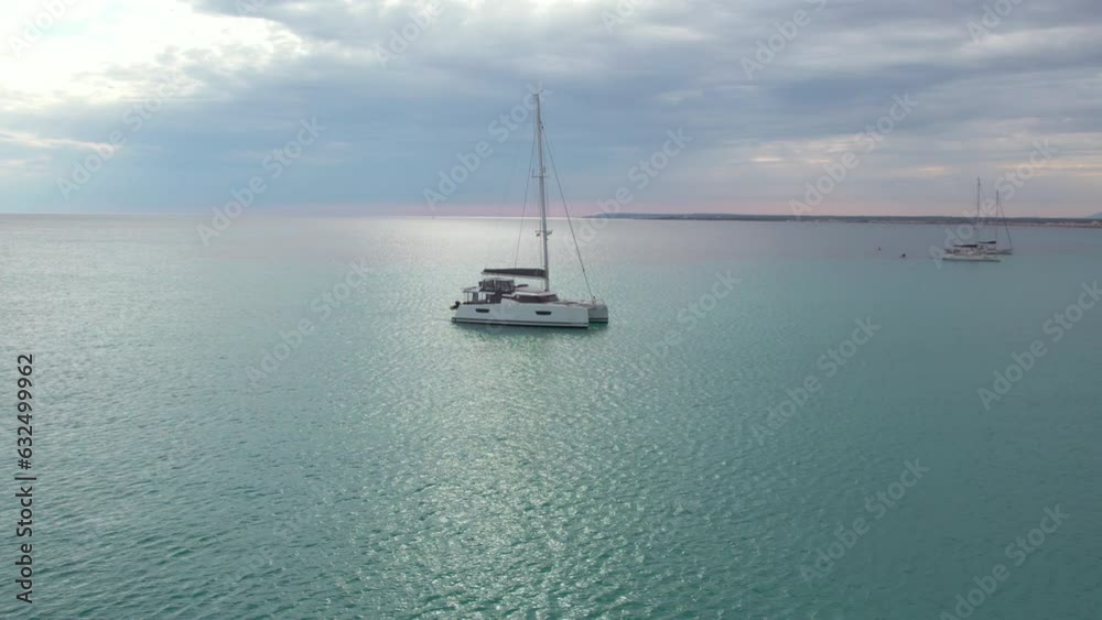 Aerial View Of A Catamaran Boat Floating In The Open Sea In Mallorca, Spain. Aerial View Of A Catamaran Boat Floating In The Open Sea In Mallorca, Spain.