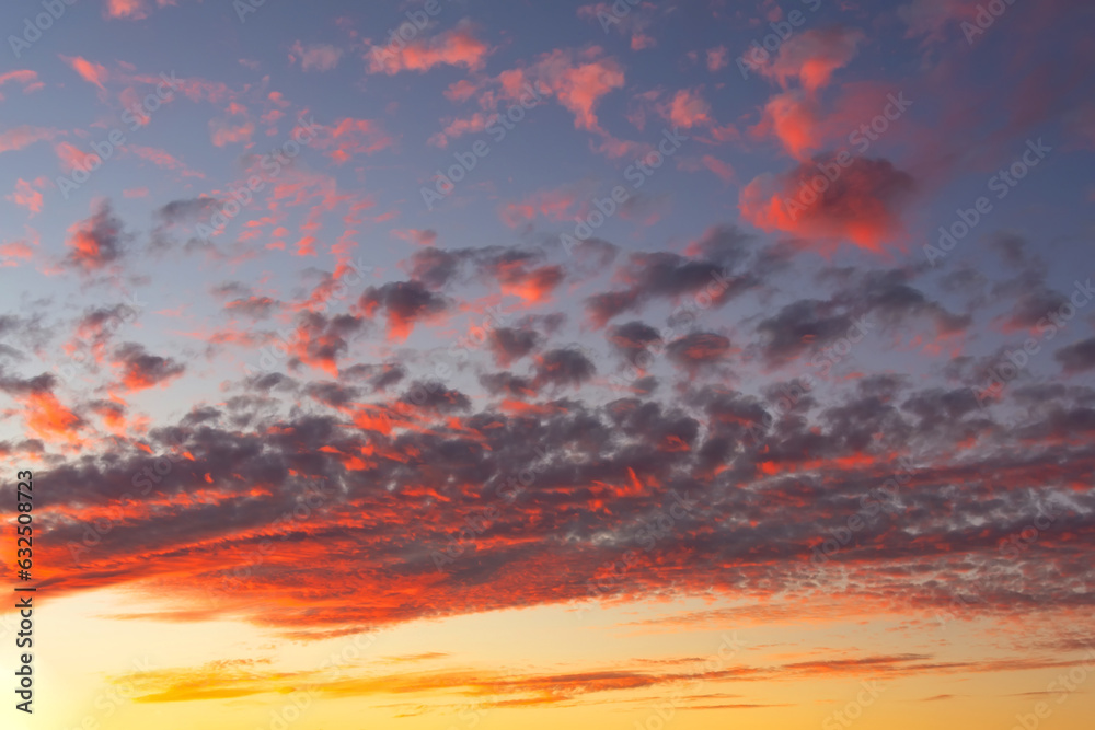 The sunrise and textured altocumulus clouds with shadows and red light in the morning.