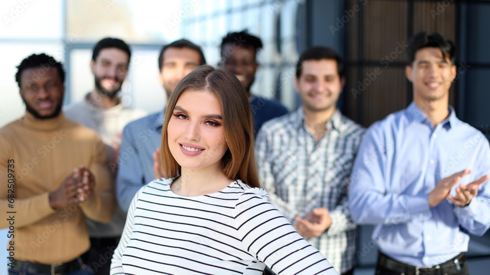 Obraz premium team clapping to the leader woman in the foreground